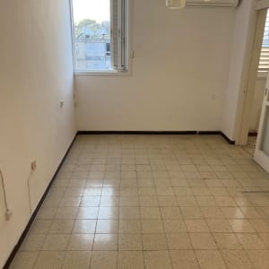 חדר ריק עם חלון ומזגן על הקיר