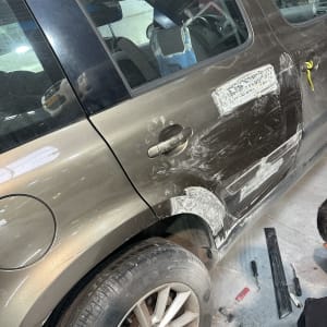 תיקון פחחות לרכב עם כלי עבודה וצבע