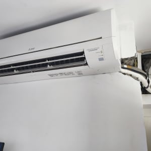 מזגן מותקן על קיר עם חיבורים גלויים