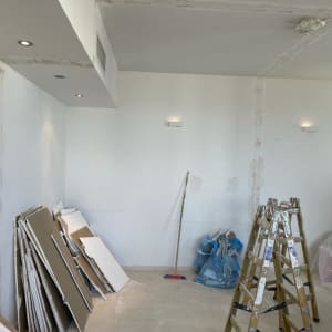 קירות גבס עם תיקונים, סולם וחומרי בנייה