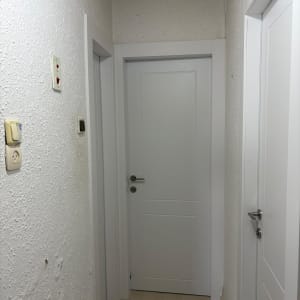 מסדרון עם דלתות לבנות וקירות מחוספסים