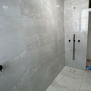 חדר אמבטיה עם אריחים חדשים ומקלחת מותקנת