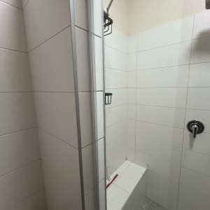 מקלחת עם אריחים לבנים, מדף וסבוניה