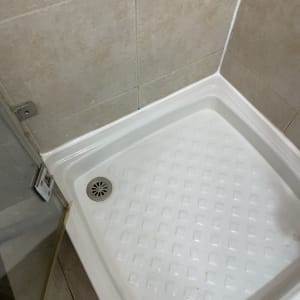 מקלחת עם רצפת קרמיקה וניקוז מתכת עגול