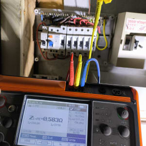 בודק חשמל עם חוטים צבעוניים ולוח חשמל