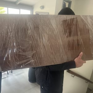 אדם נושא חפץ גדול עטוף בניילון