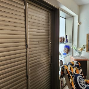 תריסים סגורים ליד כיסא עם כיסוי צבעוני