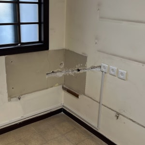 שקעים חשמליים על קיר עם חוטים חשופים