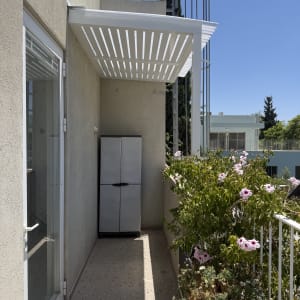 מרפסת עם פרגולה אלומיניום ופרחים