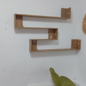 מדף עץ בצורת זיגזג על קיר לבן