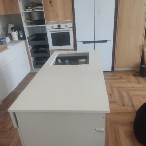 משטח שיש לבן במטבח מודרני עם ארונות עץ