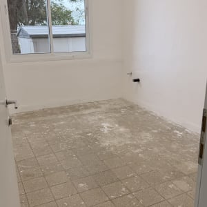 חדר ריק עם רצפת אריחים וחלון גדול