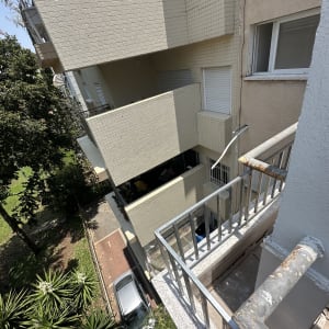 מרפסת עם מעקה מתכת ומבנה דירות