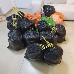 שקיות אשפה שחורות עם שרוכים צהובים על רצפה