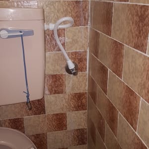 אסלה עם צינור מים מחובר לקיר