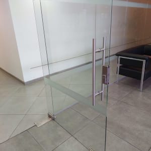 דלת זכוכית עם ידית מתכת בחדר משרדי