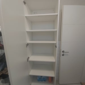 ארון מדפים פתוח עם בקבוקי פלסטיק בתחתית