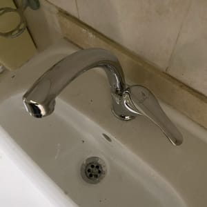 ברז כרום מותקן בכיור לבן עם ניקוז