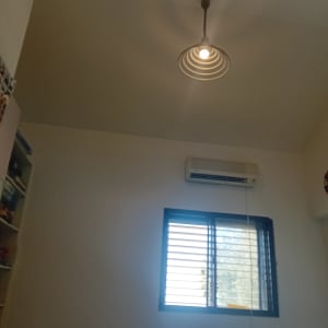 חדר מגורים עם קירות צבועים בלבן, חלון ומזגן