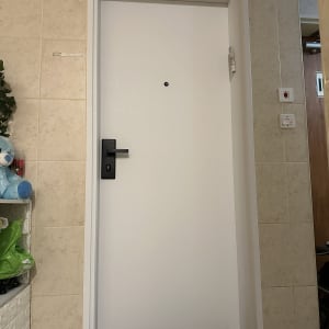 ציפוי דלת כניסה בטפט לבן חלק עם ידית שחורה ומשקוף תואם