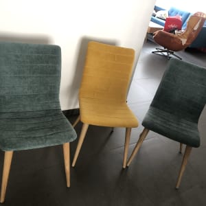 שלושה כיסאות מרופדים בצבעים שונים