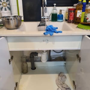 כיור מטבח עם צינור ניקוז וארון פתוח