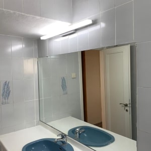 מראה גדולה מעל כיור בחדר אמבטיה