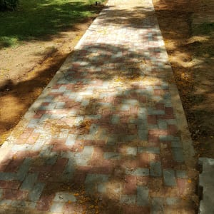 שביל מרוצף בלבנים צבעוניות בתהליך שיפוץ