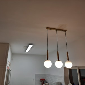 שלושה גופי תאורה תלויים מהתקרה בחדר