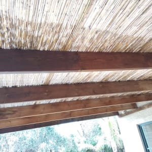 קורות עץ עם גג קנים בגינה