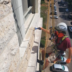 אדם מבצע איטום חלון חיצוני עם מברשת