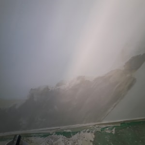 קיר עם תיקוני צבע וטיח, רצפה מכוסה בניילון