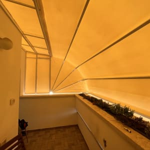 סוכך צהוב מתוח מעל מרפסת עם צמחים