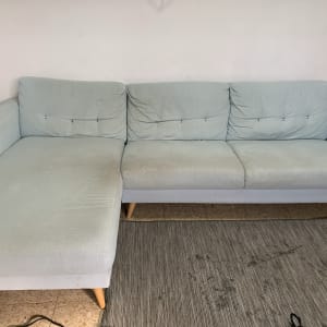 ספה בהירה עם כתמים על המושב והשטיח