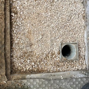 חצץ מסביב לצינור ניקוז בתוך מסגרת בטון