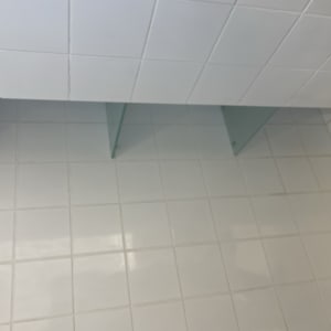 רצפת מקלחת עם אריחים לבנים וקירות זכוכית