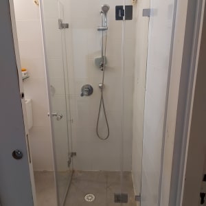 מקלחון זכוכית עם ראש מקלחת וצינור מתכת