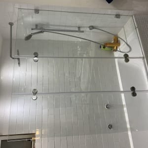 מקלחת עם דלת זכוכית, ראש מקלחת ומוצרי טיפוח