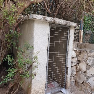 מבנה קטן עם דלת סורגים מתכתית