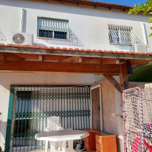 פרגולה מעץ עם שולחן וכיסא פלסטיק לבן