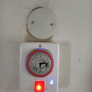 שעון טיימר חשמלי עם מתג מואר על קיר