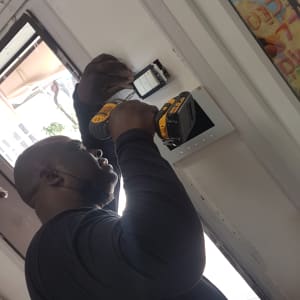 חשמלאי מתקין מתג חשמל עם מברגה חשמלית