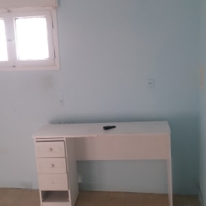 קיר צבוע בצבע תכלת עם שולחן לבן