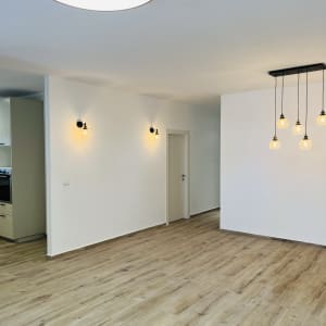 רצפת עץ חדשה ותאורה מודרנית בחדר משופץ