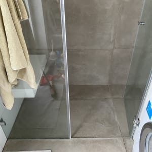 מקלחון זכוכית עם מגבות תלויים בצד