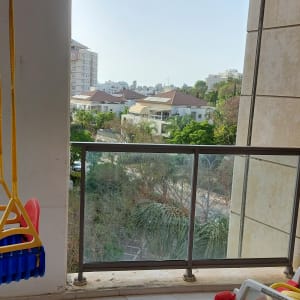 נדנדה תלויה בצבעים כחול וצהוב במרפסת