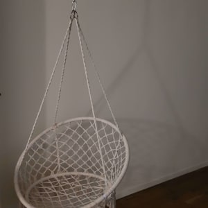 כיסא תלוי מחובר לשרשרת מתכת מהתקרה