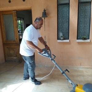 אדם מנקה רצפה עם מכונת פוליש חשמלית