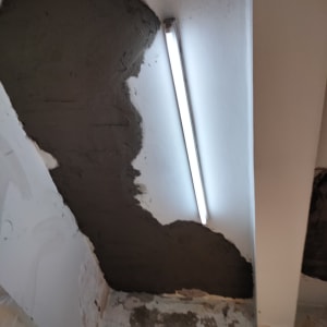 קיר עם טיח כהה ותאורת פלורסנט