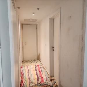 מסדרון עם קירות צבועים ויריעות מגן על הרצפה